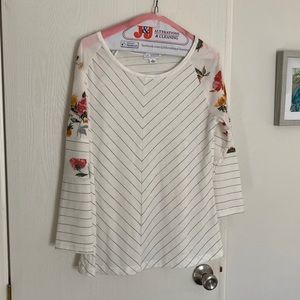 Cream color with flower design on 3/4 sleeves.  Like new